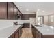 Modern kitchen featuring dark wood cabinets, white subway tile backsplash, quartz countertops and stainless steel appliances at 7229 E Cattle Call St, San Tan Valley, AZ 85143
