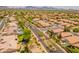 An aerial view of a neighborhood with tile roof homes, mature trees, and a community pool with mountain views at 7297 E Black Rock Rd, Scottsdale, AZ 85255