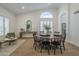 Bright dining room with round table, black chairs, arched window, and wood-look tile flooring, adjacent to sitting area at 7297 E Black Rock Rd, Scottsdale, AZ 85255