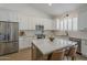 Spacious kitchen with stainless steel appliances, white cabinetry, and a central island with seating at 7297 E Black Rock Rd, Scottsdale, AZ 85255
