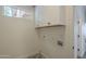 Bright laundry room boasts upper cabinets, utility connections, and neutral flooring for a functional space at 7297 E Black Rock Rd, Scottsdale, AZ 85255
