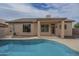 Backyard featuring a refreshing pool, tan patio, covered porch, desert landscaping, and home exterior at 7297 E Black Rock Rd, Scottsdale, AZ 85255