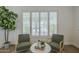 Serene sitting area with green chairs, a round table and large windows with shutters, providing ample natural light at 7297 E Black Rock Rd, Scottsdale, AZ 85255