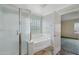 Bright bathroom boasting a glass-enclosed shower, separate soaking tub, and privacy window at 7546 W Mary Jane Ln, Peoria, AZ 85382