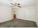 Bedroom featuring carpet flooring, a ceiling fan, and closet with mirrored sliding doors at 7546 W Mary Jane Ln, Peoria, AZ 85382