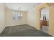 Carpeted dining room with a hanging chandelier, neutral walls, and a window with shutters for natural light at 7546 W Mary Jane Ln, Peoria, AZ 85382
