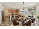 Dining room featuring neutral colors, modern chandelier, with an adjacent kitchen and barstool seating at 7546 W Mary Jane Ln, Peoria, AZ 85382