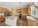 Well-lit kitchen with tile flooring, center island, wood cabinets, stainless steel appliances, and neutral countertops at 7546 W Mary Jane Ln, Peoria, AZ 85382