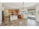 A bright kitchen with tile floors, an island, stainless steel appliances and a sliding door leading to the backyard at 7546 W Mary Jane Ln, Peoria, AZ 85382