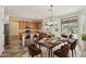 An open-concept kitchen flowing to dining area, featuring ample seating, stainless appliances, and natural light from a sliding glass door at 7546 W Mary Jane Ln, Peoria, AZ 85382