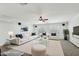 A bright, modern living room with white furniture, plush rug, and a ceiling fan at 7546 W Mary Jane Ln, Peoria, AZ 85382