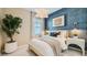 Cozy bedroom showcasing a plush bed with decorative pillows, stylish lighting fixtures, and a decorative accent wall at 8149 E Petunia Ave # 1007, Mesa, AZ 85212