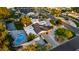 Stunning aerial view of home with a pool, tennis court, and circular driveway at 8230 E Wood Dr, Scottsdale, AZ 85260