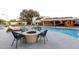 Resort-style backyard featuring a pool, fire pit, and lounge area, perfect for relaxation and recreation at 8230 E Wood Dr, Scottsdale, AZ 85260