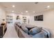 Finished basement with a large sectional sofa, built-in shelving, and a modern entertainment setup at 8230 E Wood Dr, Scottsdale, AZ 85260