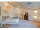 Airy bedroom featuring a unique chandelier, fan, and hardwood floors at 8230 E Wood Dr, Scottsdale, AZ 85260