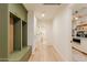 Hallway with wooden floors, custom green cabinetry, and access to several rooms with white colored walls at 8230 E Wood Dr, Scottsdale, AZ 85260