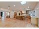 Spacious kitchen with a large central island, wooden cabinets and chairs, and modern lighting fixtures at 8230 E Wood Dr, Scottsdale, AZ 85260