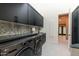 This laundry room features stylish black cabinets, modern washer and dryer, and designer tile backsplash at 8230 E Wood Dr, Scottsdale, AZ 85260