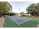 Private sports court with basketball hoop and tennis net, set against lush landscaping for year-round enjoyment at 8230 E Wood Dr, Scottsdale, AZ 85260