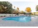 Beautifully landscaped backyard with a freeform swimming pool, lounge chairs, and mature trees for serene outdoor living at 8230 E Wood Dr, Scottsdale, AZ 85260