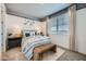 Comfortable bedroom with stylish decor, a large window and a cozy bench at 8251 E Petunia Ave, Mesa, AZ 85212