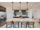 Well-lit kitchen island with seating and pendant lights, showcasing stainless steel appliances and sleek, dark cabinetry at 8251 E Petunia Ave, Mesa, AZ 85212
