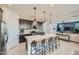 Modern kitchen featuring a large island with seating, pendant lighting, stainless steel appliances, and dark cabinetry at 8251 E Petunia Ave, Mesa, AZ 85212