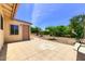 A spacious backyard featuring a tiled patio, desert landscaping, and mature trees offering shade and a tranquil outdoor space at 863 Leisure World --, Mesa, AZ 85206