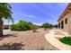 Large backyard with desert landscaping, mature trees, and a curved walkway leading toward the house at 863 Leisure World --, Mesa, AZ 85206