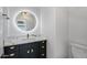 Stylish bathroom with a black vanity, round mirror, quartz countertop, and modern fixtures at 8913 S Forest Ave, Tempe, AZ 85284