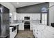 Modern kitchen with white cabinets, stainless steel appliances, quartz countertops, and hardwood floors at 8913 S Forest Ave, Tempe, AZ 85284
