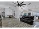 Spacious living area with a modern ceiling fan, a dining area and comfortable leather sofa at 8913 S Forest Ave, Tempe, AZ 85284
