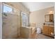 Bright bathroom featuring tiled shower, bathtub, and a window for natural light at 93 S Sandstone St, Gilbert, AZ 85296