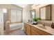 Bathroom featuring a tub-shower combo, double sinks, and a large window providing great natural light at 93 S Sandstone St, Gilbert, AZ 85296