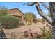 View of native desert landscaped backyard from beneath a tree with bench seating at 1029 E Ian Dr, Phoenix, AZ 85042
