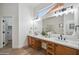 Bathroom vanity with double sinks, wood cabinets, and a large mirror at 1029 E Ian Dr, Phoenix, AZ 85042