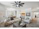 Bright living room with contemporary furniture, ceiling fan, and open to the kitchen at 1029 E Ian Dr, Phoenix, AZ 85042