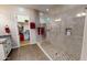 Modern bathroom featuring a stand up shower with tiled walls, glass doors, storage coves and a walk in closet at 10507 S 181St Ave, Goodyear, AZ 85338