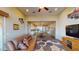 Spacious living room area with a ceiling fan and tan sofa leading to a view of an open concept kitchen and dining area at 10507 S 181St Ave, Goodyear, AZ 85338