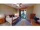 Comfortable main bedroom with dark wooden furniture, neutral walls, ceiling fan, and sliding glass door access to the outside at 10507 S 181St Ave, Goodyear, AZ 85338