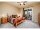 Comfortable bedroom with natural light, en-suite bathroom, and sliding glass door to private balcony at 10507 S 181St Ave, Goodyear, AZ 85338