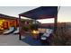 Relaxing pergola area featuring a lounge set, and comfortable furniture, with a brick patio and surrounding greenery at 10507 S 181St Ave, Goodyear, AZ 85338