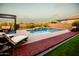 Backyard pool with waterfall, lounge chairs and an outdoor firepit at 10507 S 181St Ave, Goodyear, AZ 85338