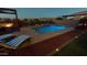 Tranquil pool area at dusk featuring lounge chairs, brick landscaping, and mountain views in the distance at 10507 S 181St Ave, Goodyear, AZ 85338