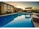 A serene backyard with a pool, waterfall feature, and covered patio at 10507 S 181St Ave, Goodyear, AZ 85338