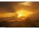 Sunrise with sun rays peeking through the clouds over the silhouette of homes and mountains at 10507 S 181St Ave, Goodyear, AZ 85338