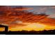 Beautiful sunset with stunning orange clouds over the silhouette of a residential community and mountain range at 10507 S 181St Ave, Goodyear, AZ 85338
