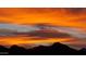 Vibrant sunset over the mountain range with dramatic orange and gray cloud formations at 10507 S 181St Ave, Goodyear, AZ 85338