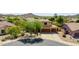 Aerial view featuring a home with a three-car garage and mature landscaping in a desert community at 11150 S Star Ct, Goodyear, AZ 85338